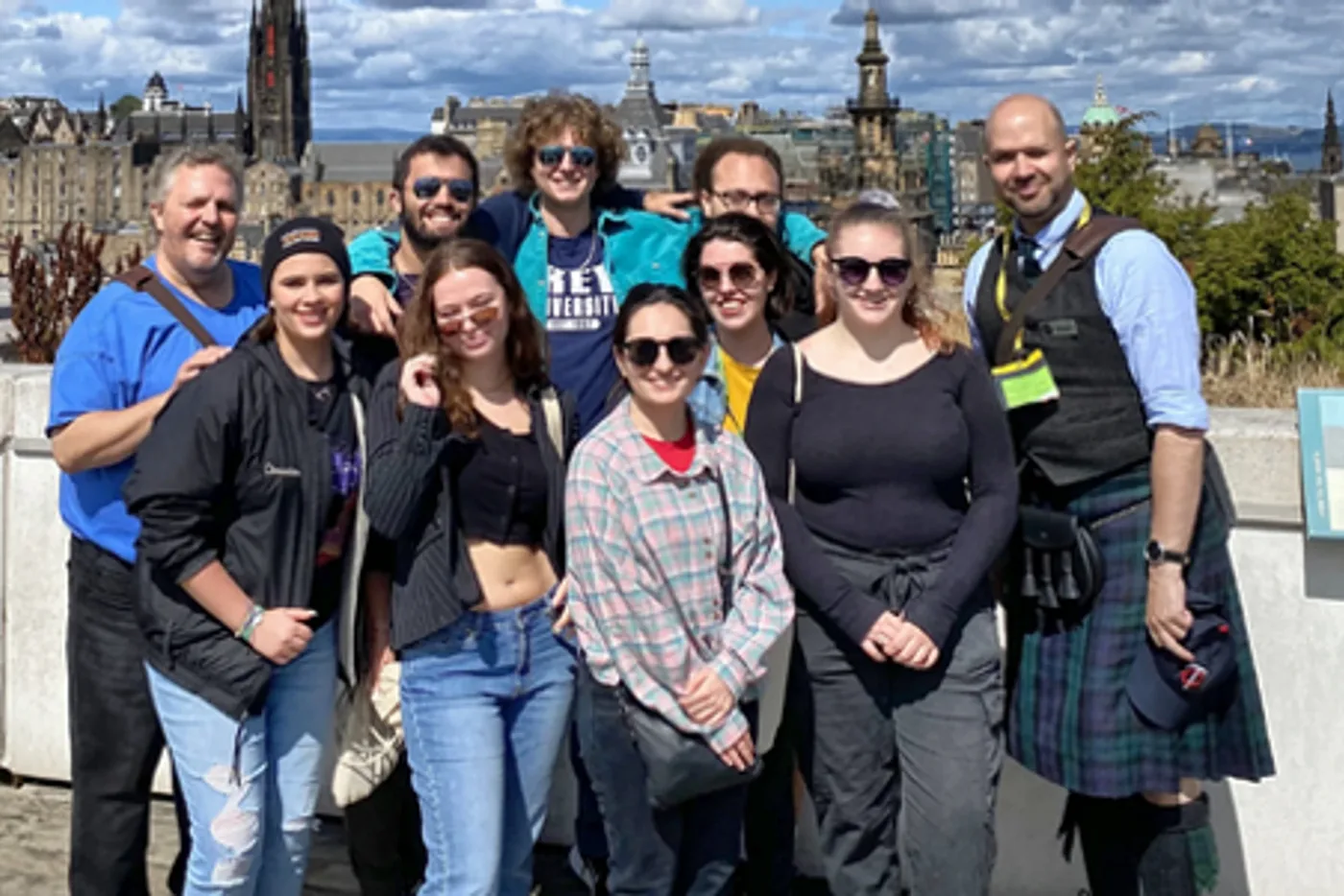 A large tour group photographed together on Calton Hill